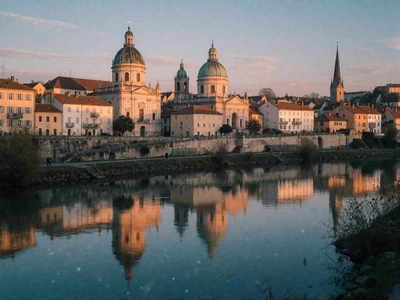 European riverside old town with domes and spires reflected at dusk